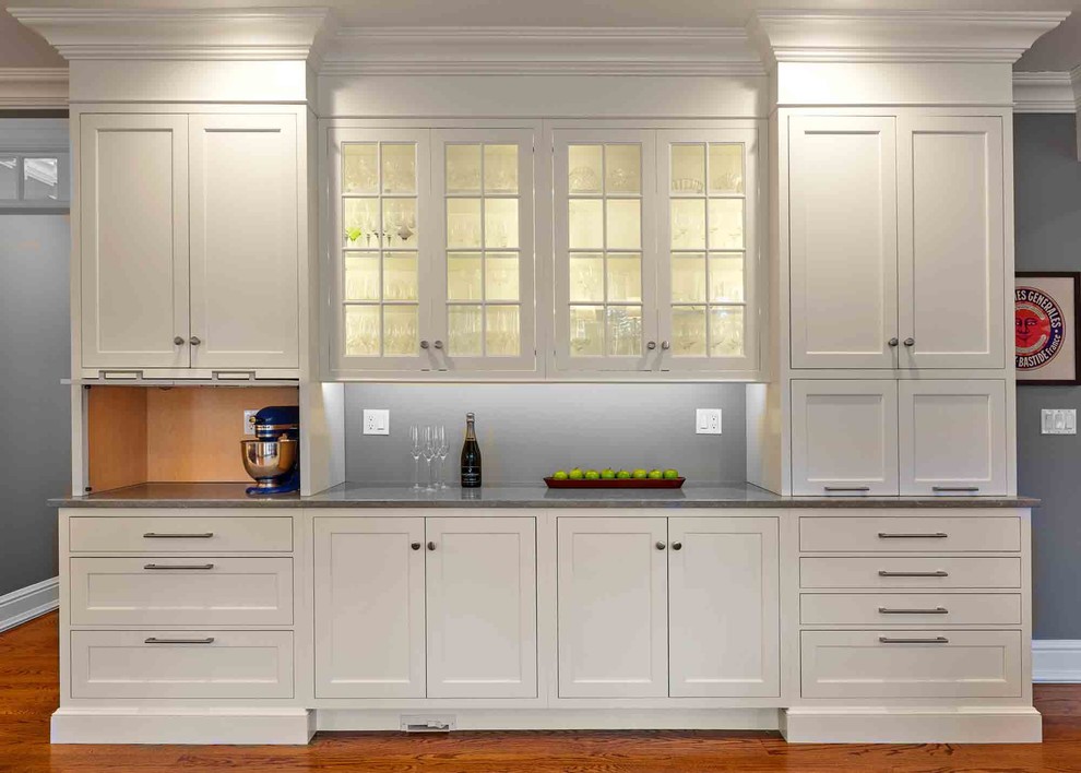 Example of a large transitional l-shaped medium tone wood floor and brown floor eat-in kitchen design in Bridgeport with a drop-in sink, beaded inset cabinets, white cabinets, limestone countertops, white backsplash, ceramic backsplash, stainless steel appliances, an island and gray countertops