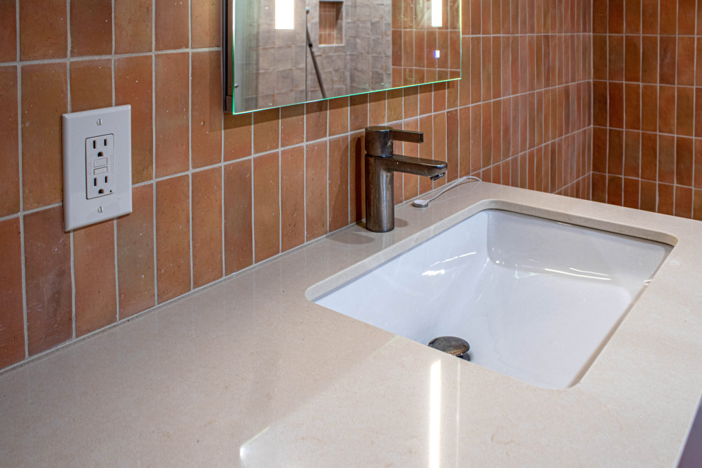 Mid-sized midcentury master bathroom in Cleveland with flat-panel cabinets, beige cabinets, an alcove tub, a curbless shower, a one-piece toilet, brown tile, ceramic tile, beige walls, ceramic floors, an undermount sink, engineered quartz benchtops, red floor, a hinged shower door, beige benchtops, a niche, a single vanity and a built-in vanity.