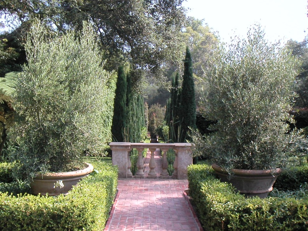 Large mediterranean backyard formal garden in Santa Barbara with with pond and brick pavers.