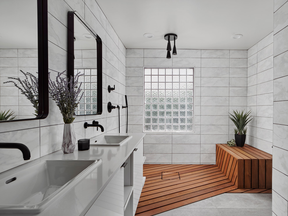 This is an example of a modern wet room bathroom in Phoenix with flat-panel cabinets, white cabinets, white tile, concrete benchtops, an open shower, white benchtops, a shower seat, a double vanity and a floating vanity.