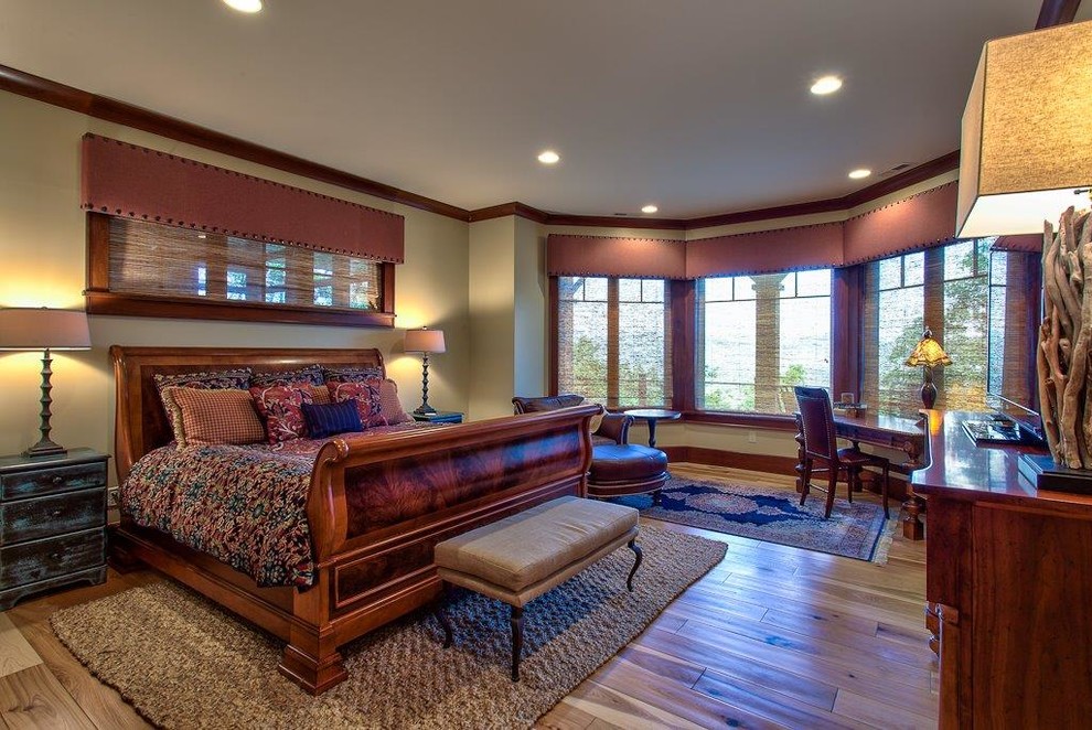This is an example of a large arts and crafts master bedroom in Other with green walls, light hardwood floors, no fireplace and brown floor.
