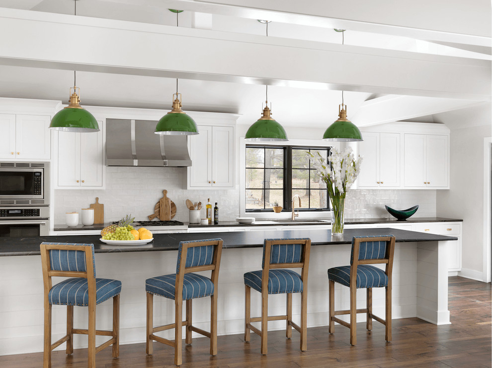 Design ideas for a transitional kitchen in St Louis with shaker cabinets, white cabinets, soapstone benchtops, white splashback, with island, brown floor, stainless steel appliances and dark hardwood floors.