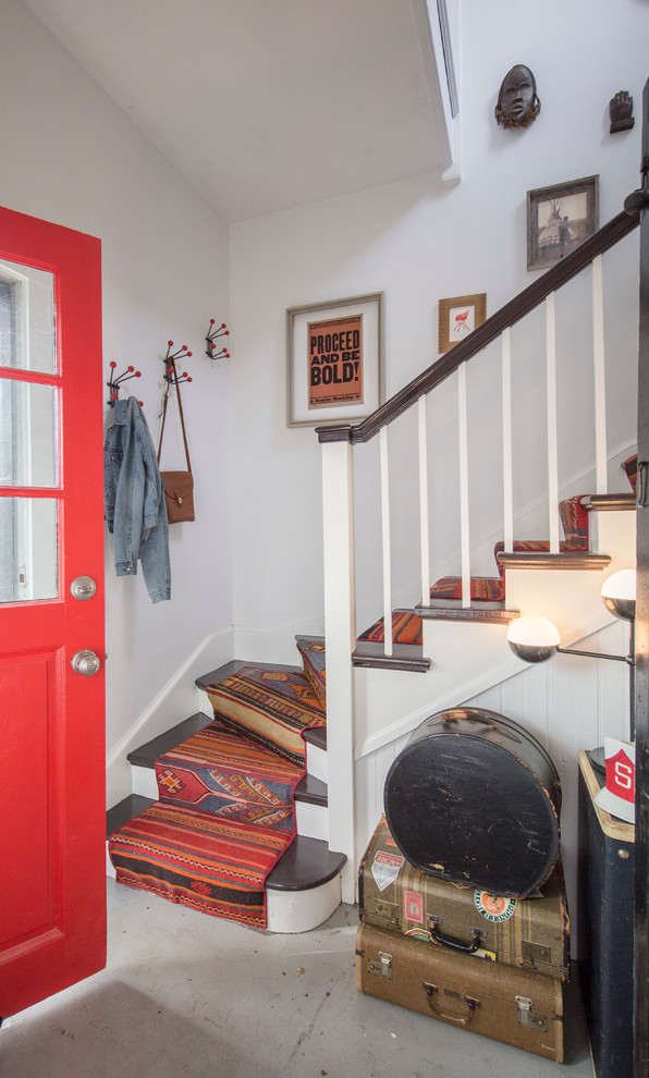 Photo of a small eclectic foyer in Chicago with white walls, concrete floors, a single front door and a red front door.