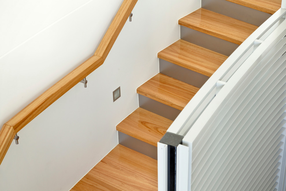 Photo of a large contemporary wood curved staircase in Brisbane with wood railing.