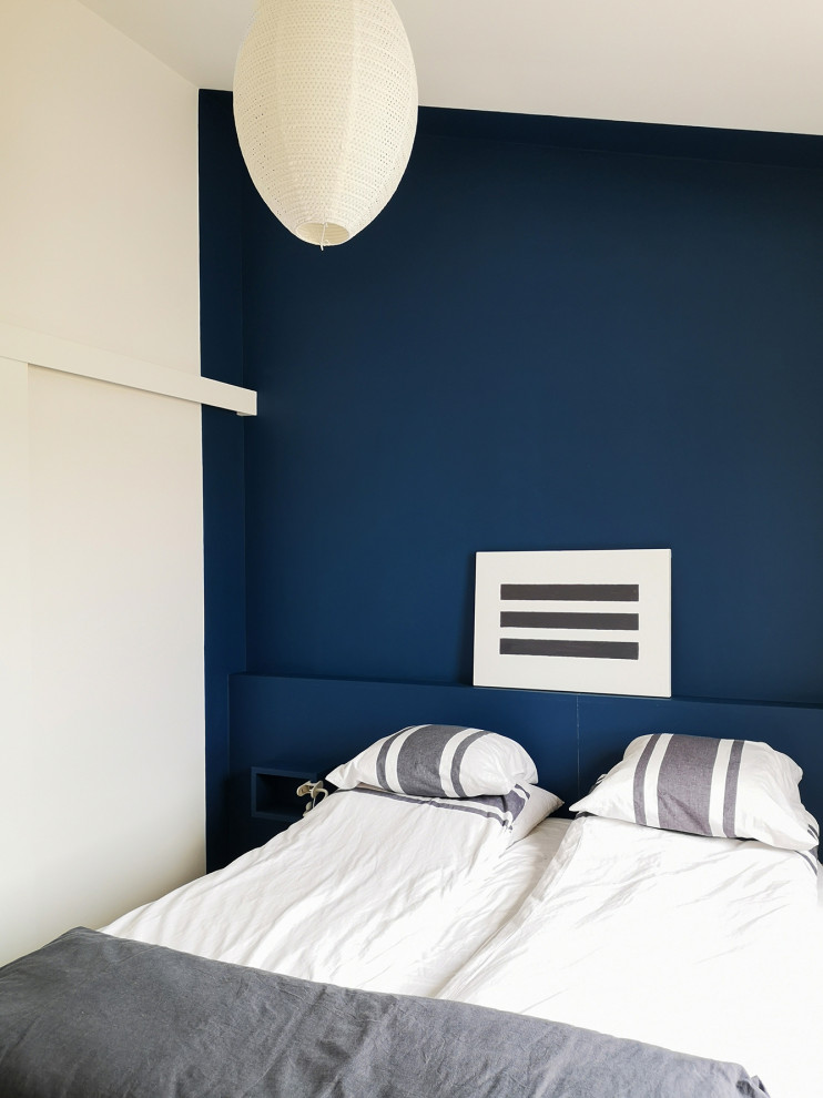 This is an example of a small beach style bedroom in Other with blue walls.