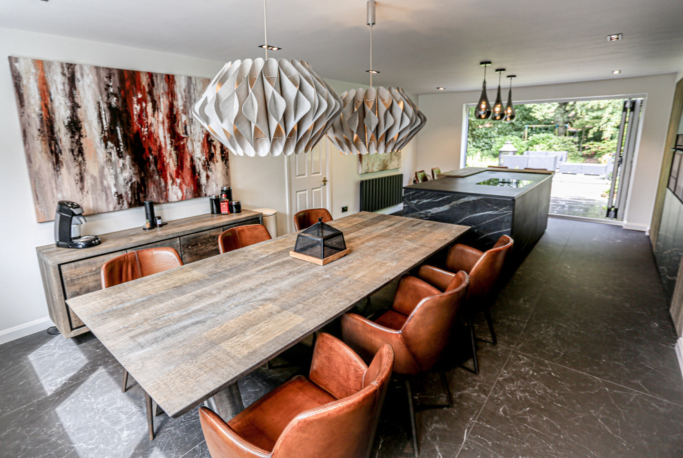 На фото: большая кухня-столовая в стиле модернизм с полом из керамогранита и черным полом с