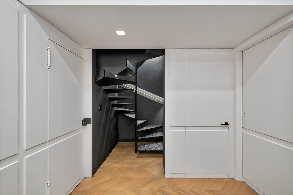 Photo of a small contemporary spiral staircase in New York with open risers and metal railing.