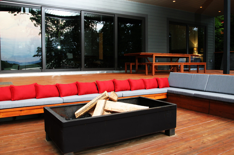 Inspiration for a large modern backyard deck remodel in Atlanta with a fire pit and a roof extension