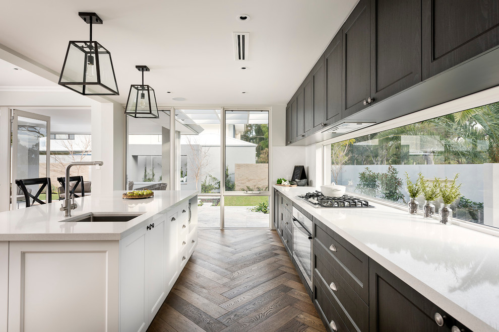 This is an example of a large traditional single-wall eat-in kitchen in Perth with an undermount sink, black cabinets, white splashback, stainless steel appliances, dark hardwood floors and with island.