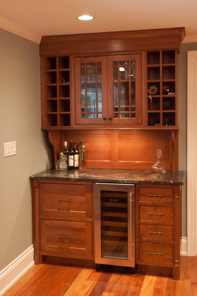 Photo of a mid-sized traditional single-wall wet bar in Boston with shaker cabinets, light wood cabinets, marble benchtops, brown splashback and light hardwood floors.