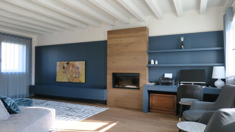 Источник вдохновения для домашнего уюта: гостиная комната в современном стиле с синими стенами, деревянным полом, стандартным камином, фасадом камина из дерева и панелями на стенах