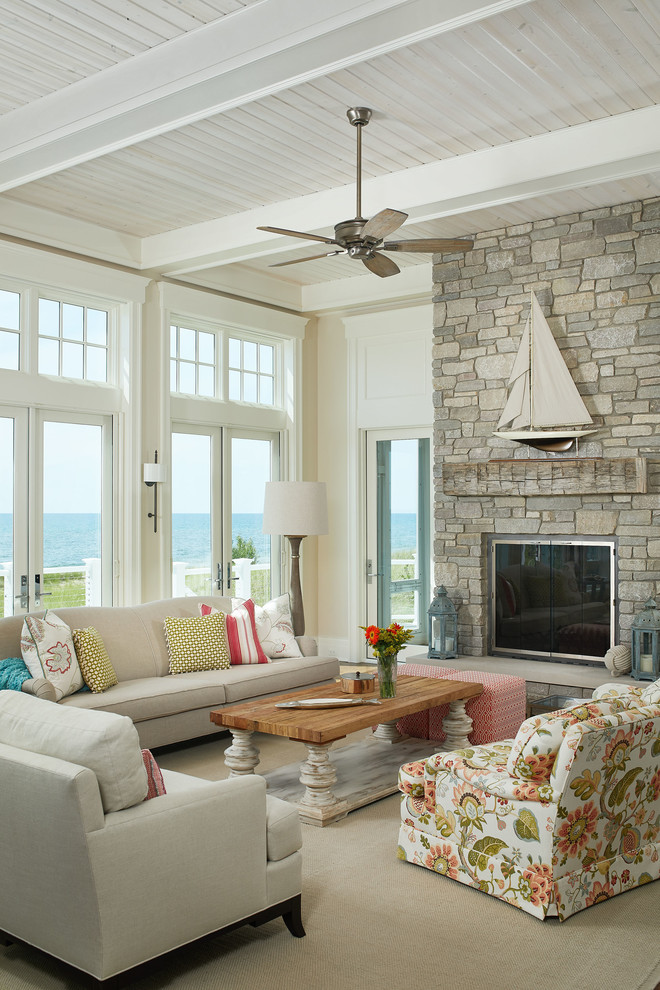 Beach style living room photo in Grand Rapids with beige walls, a standard fireplace and a stone fireplace