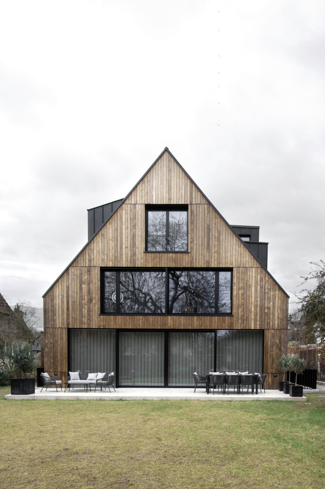 Inspiration pour une façade de maison beige minimaliste en bois et bardage à clin à un étage avec un toit à deux pans, un toit en métal et un toit noir.