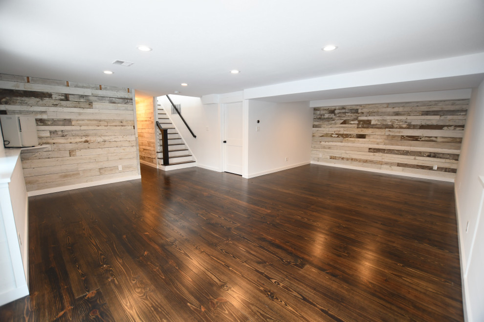 Design ideas for a large midcentury walk-out basement in New York with white walls, medium hardwood floors, no fireplace and brown floor.