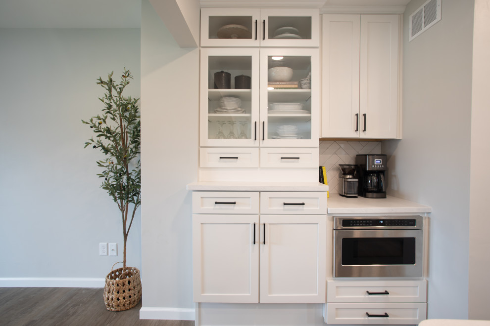 Kitchen - transitional vinyl floor kitchen idea with shaker cabinets, white cabinets, quartz countertops, white backsplash, porcelain backsplash, stainless steel appliances and white countertops