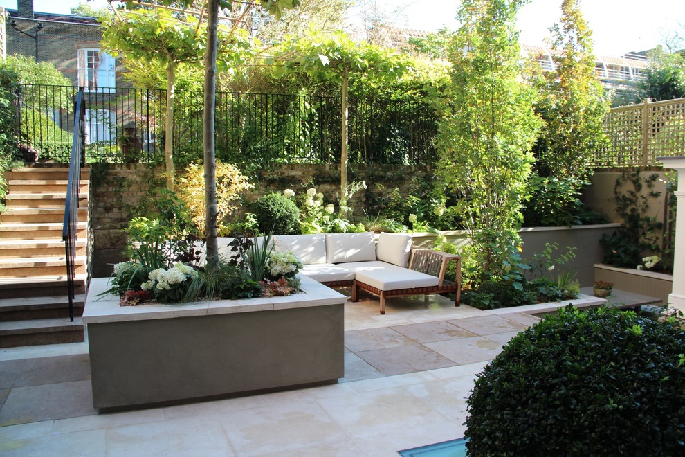 Photo of a mid-sized contemporary backyard garden in London with a garden path and natural stone pavers.