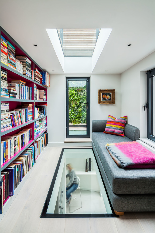 Contemporary family room in London with a library and white walls.