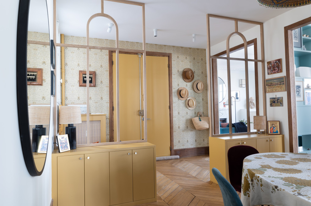 This is an example of a mid-sized transitional foyer in Paris with yellow walls, light hardwood floors, a double front door, a yellow front door and beige floor.