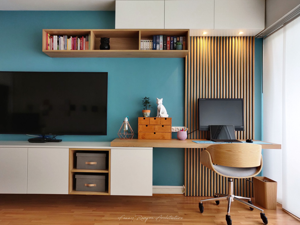 Immagine di un piccolo soggiorno minimal chiuso con pareti blu, parquet chiaro e TV a parete