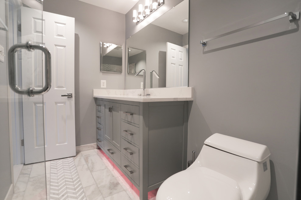 Photo of a mid-sized contemporary bathroom in DC Metro with shaker cabinets, grey cabinets, a shower/bathtub combo, a one-piece toilet, white tile, marble, grey walls, marble floors, an undermount sink, quartzite benchtops, white floor and a sliding shower screen.