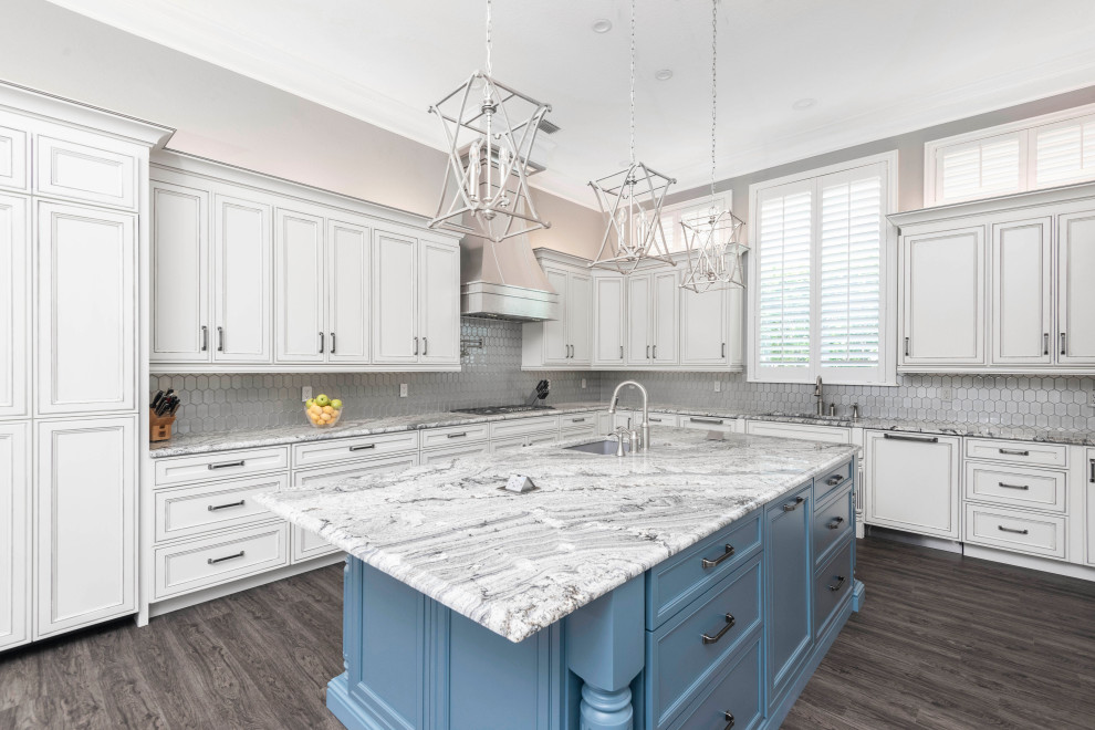 Kitchen - large transitional u-shaped laminate floor and multicolored floor kitchen idea in Orlando with an undermount sink, recessed-panel cabinets, white cabinets, granite countertops, metallic backsplash, glass tile backsplash, paneled appliances, an island and gray countertops
