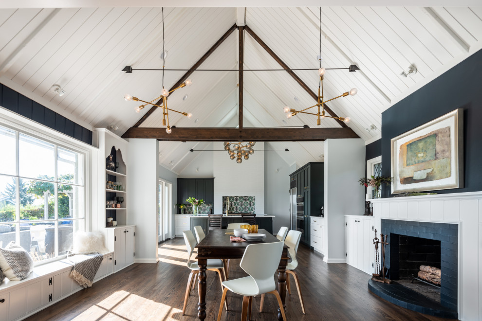 Design ideas for a transitional open plan dining in Seattle with blue walls, dark hardwood floors, a standard fireplace, a brick fireplace surround, brown floor, timber and vaulted.