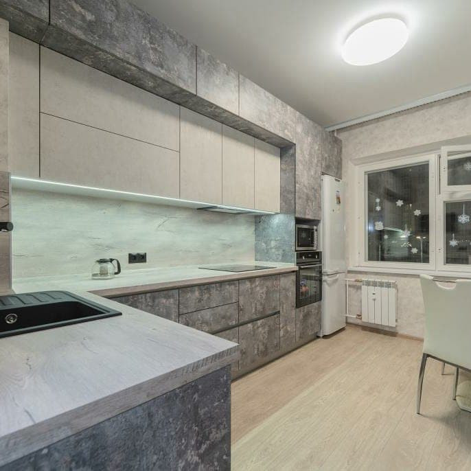 Example of a large urban l-shaped medium tone wood floor and brown floor eat-in kitchen design in Saint Petersburg with a drop-in sink, recessed-panel cabinets, white cabinets, wood countertops, gray backsplash, wood backsplash, black appliances, no island and gray countertops