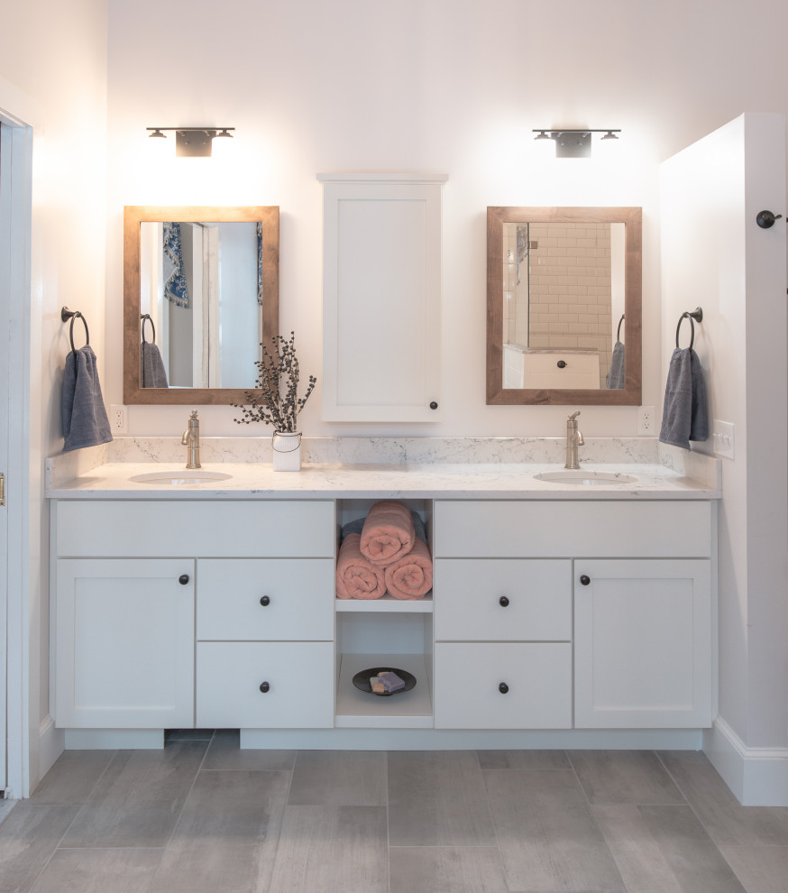 Example of a large cottage master white tile and porcelain tile porcelain tile, gray floor and double-sink bathroom design in Boston with shaker cabinets, white cabinets, a one-piece toilet, white walls, an undermount sink, quartz countertops, a hinged shower door, white countertops, a niche and a built-in vanity