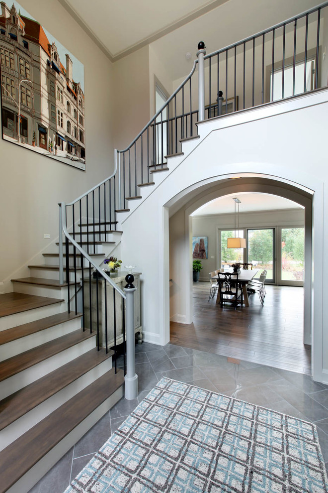 This is an example of a transitional foyer in Grand Rapids with beige walls, porcelain floors and grey floor.
