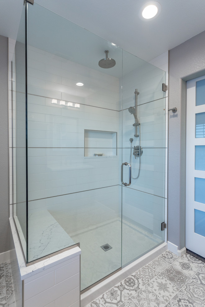 Mid-sized contemporary master bathroom in Denver with furniture-like cabinets, medium wood cabinets, a corner shower, a two-piece toilet, gray tile, ceramic tile, grey walls, ceramic floors, an undermount sink and engineered quartz benchtops.