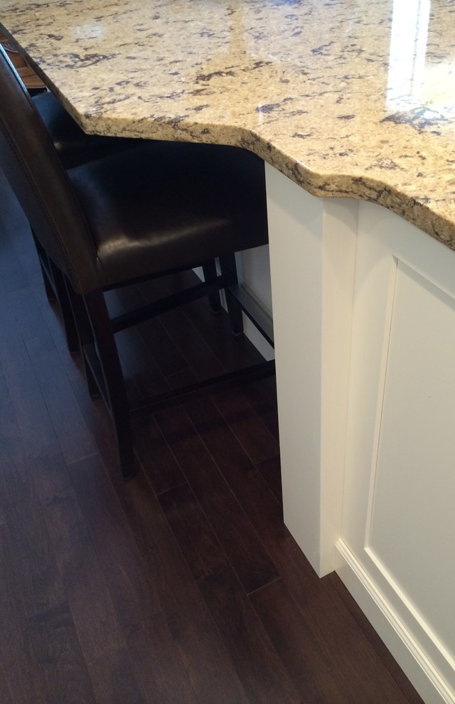 Inspiration for a large transitional dark wood floor kitchen remodel in New York with a farmhouse sink, flat-panel cabinets, white cabinets, quartz countertops, stainless steel appliances and an island