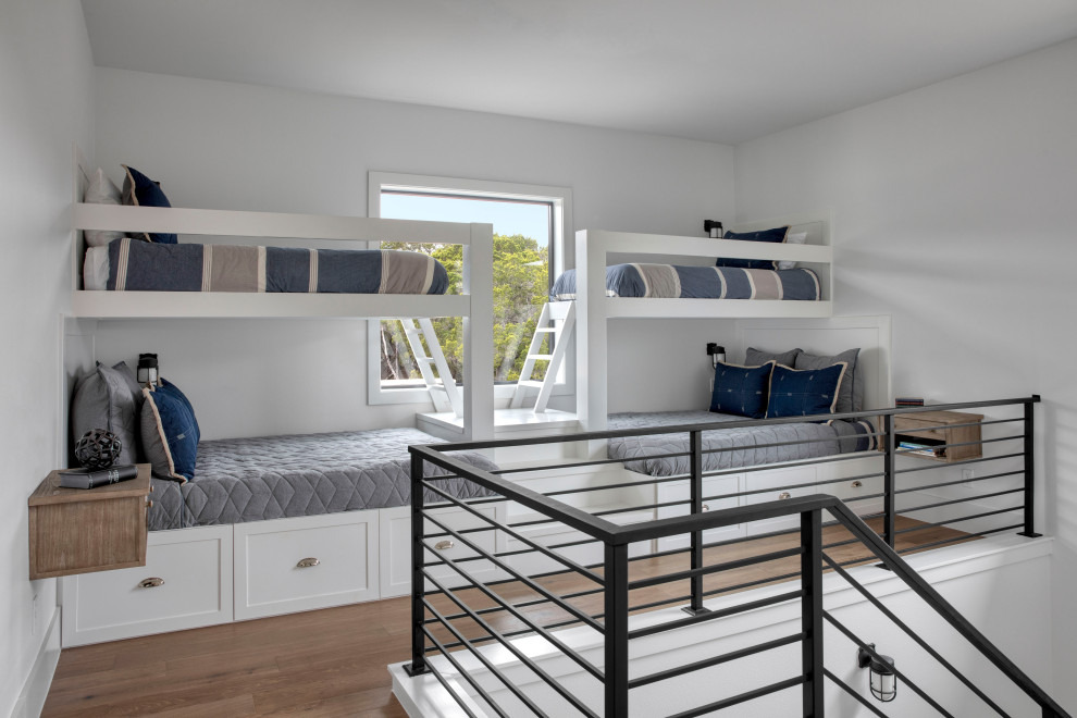 Imagen de dormitorio infantil campestre de tamaño medio con paredes blancas y suelo de madera clara