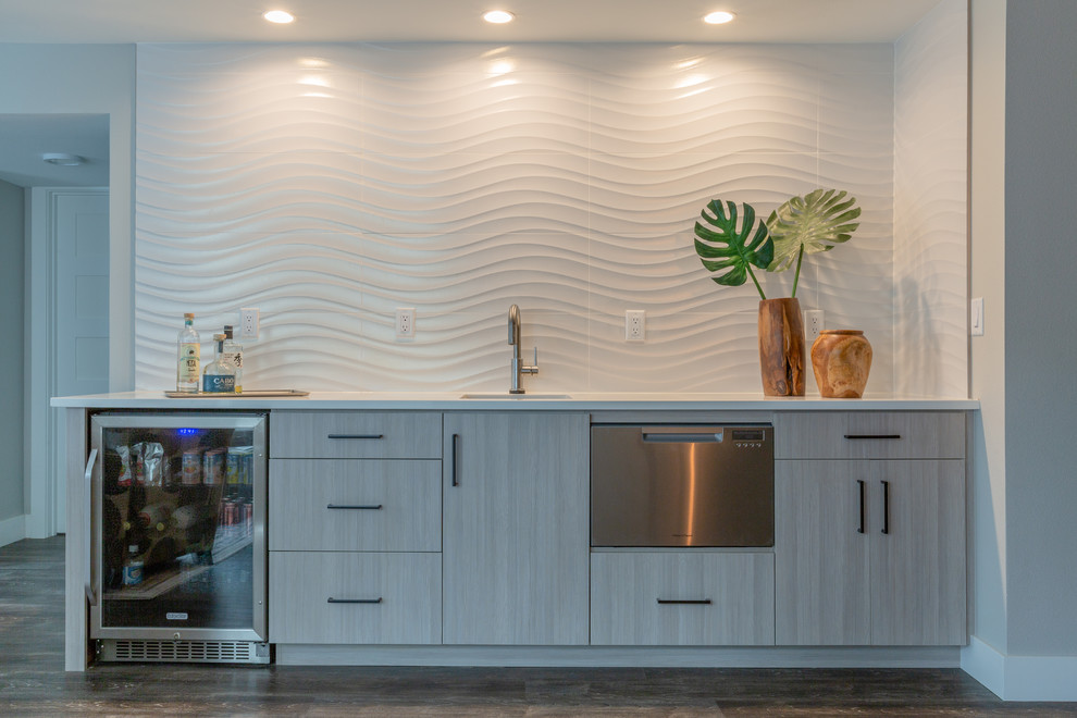 Contemporary single-wall wet bar in Denver with laminate floors, grey floor, an undermount sink, flat-panel cabinets, grey cabinets, white splashback and white benchtop.