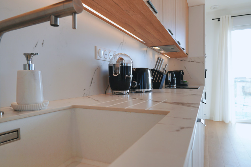Photo of a mid-sized scandinavian eat-in kitchen in Other with light hardwood floors.