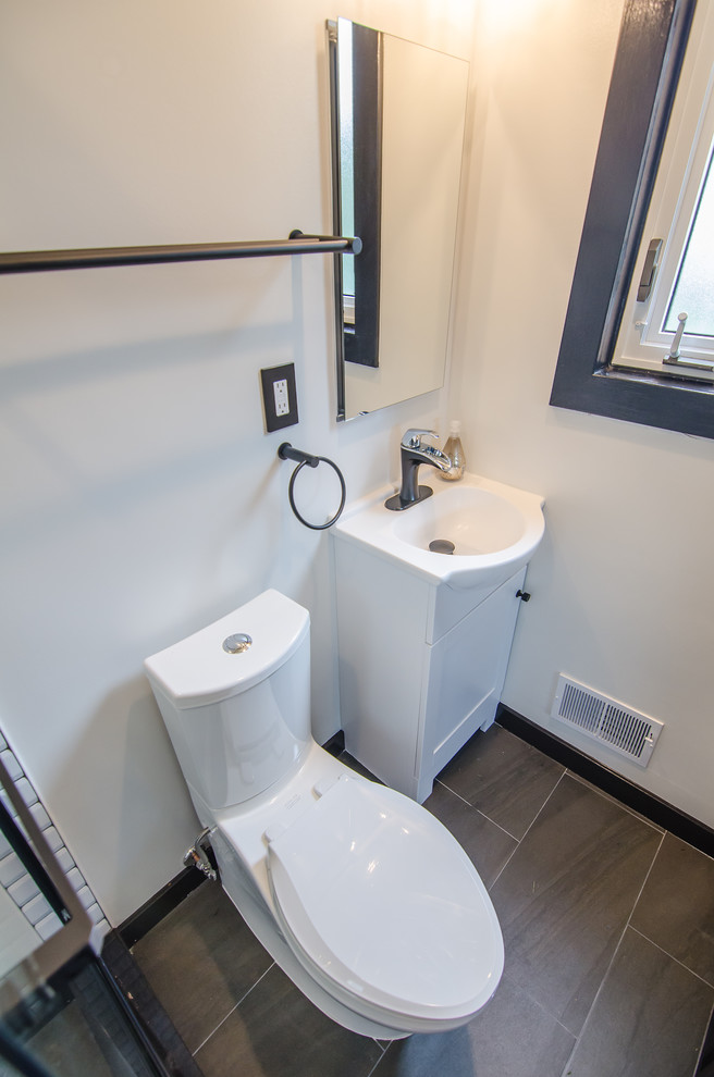 Small contemporary master bathroom in DC Metro with shaker cabinets, white cabinets, an alcove shower, a two-piece toilet, black and white tile, ceramic tile, porcelain floors, an integrated sink, solid surface benchtops, black floor, a sliding shower screen and white benchtops.