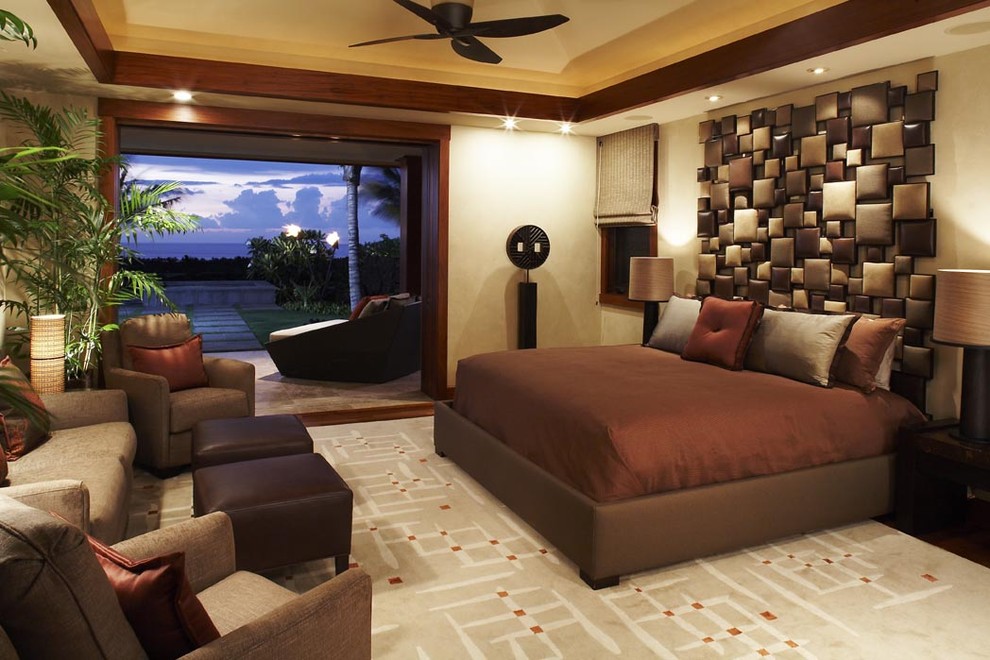 This is an example of a tropical master bedroom in Hawaii with beige walls.