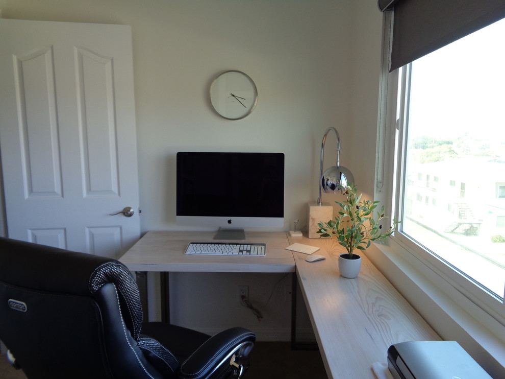 Photo of a small contemporary study room in Los Angeles with white walls, carpet, a freestanding desk and beige floor.