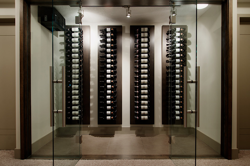 This is an example of a modern wine cellar in Calgary with porcelain floors.