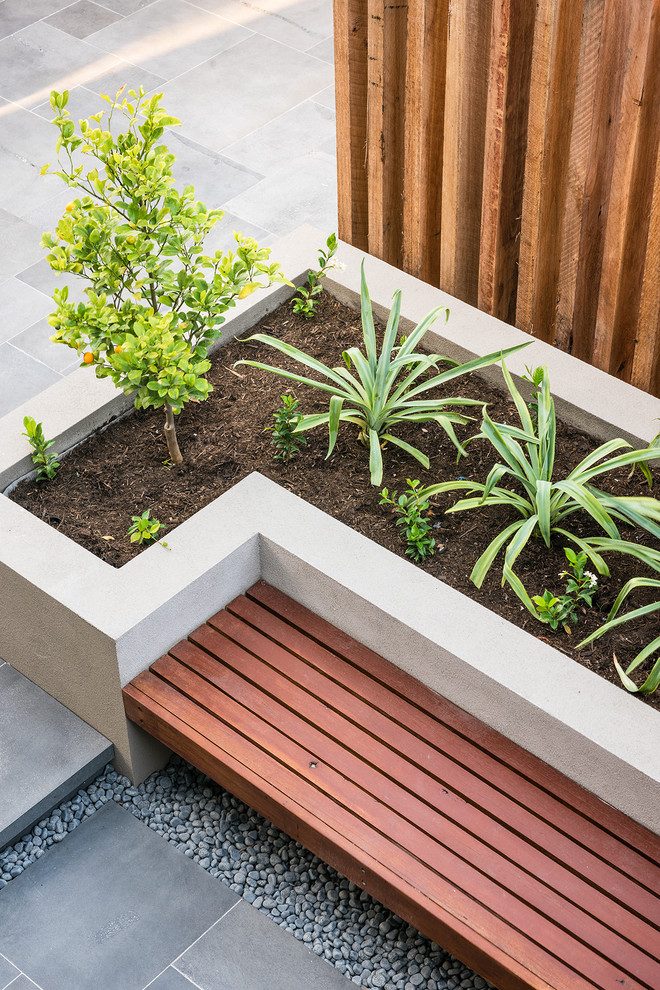 Mid-sized contemporary side yard partial sun garden in Melbourne with natural stone pavers.