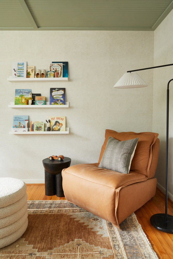 Diseño de habitación de bebé neutra de estilo americano pequeña con paredes beige, suelo de madera en tonos medios, suelo marrón, madera y papel pintado