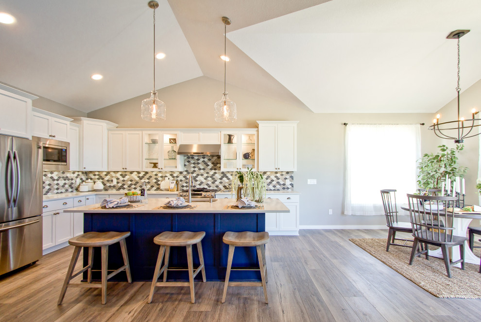 Inspiration for a transitional brown floor and vinyl floor kitchen remodel with an undermount sink, recessed-panel cabinets, white cabinets, quartz countertops, multicolored backsplash, mosaic tile backsplash, an island and white countertops