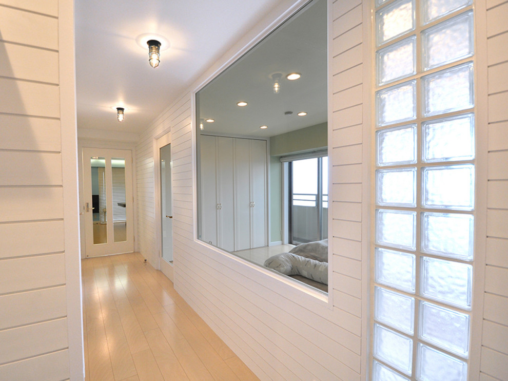 Idée de décoration pour un couloir marin de taille moyenne avec un mur blanc, parquet peint, un sol marron et du lambris.