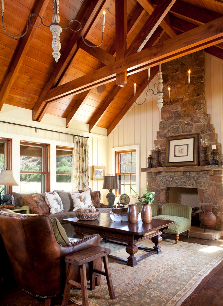 Country living room in Denver with beige walls, dark hardwood floors, a standard fireplace and a stone fireplace surround.
