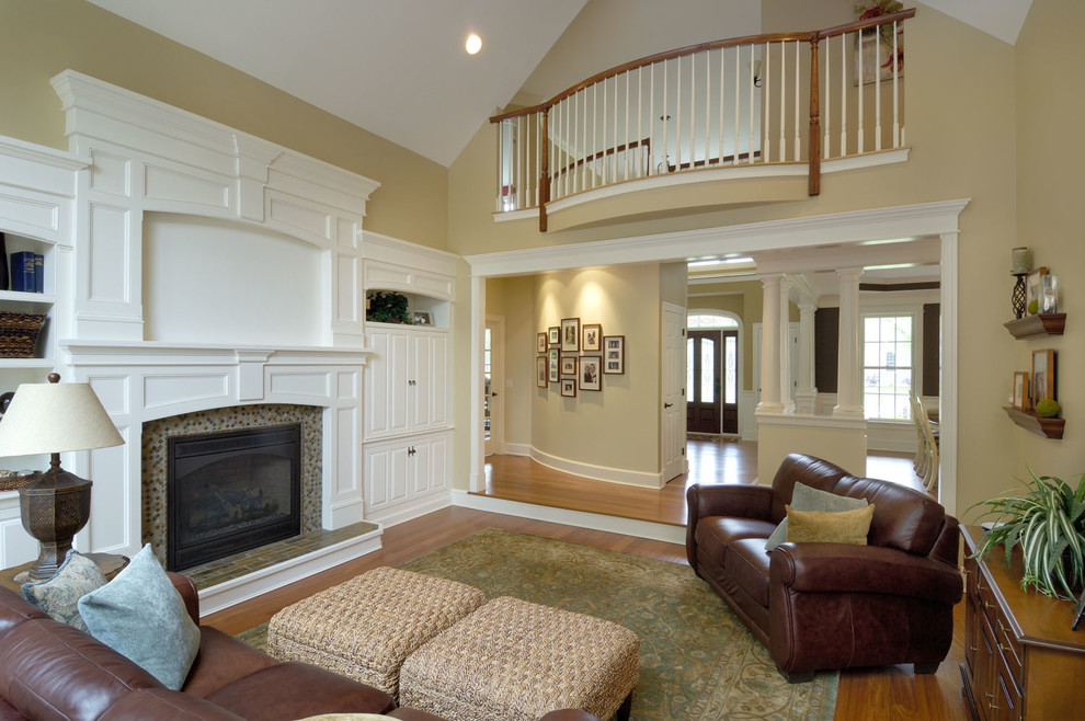 Mid-sized traditional enclosed family room in Boston with no tv, yellow walls, medium hardwood floors, a standard fireplace and a tile fireplace surround.