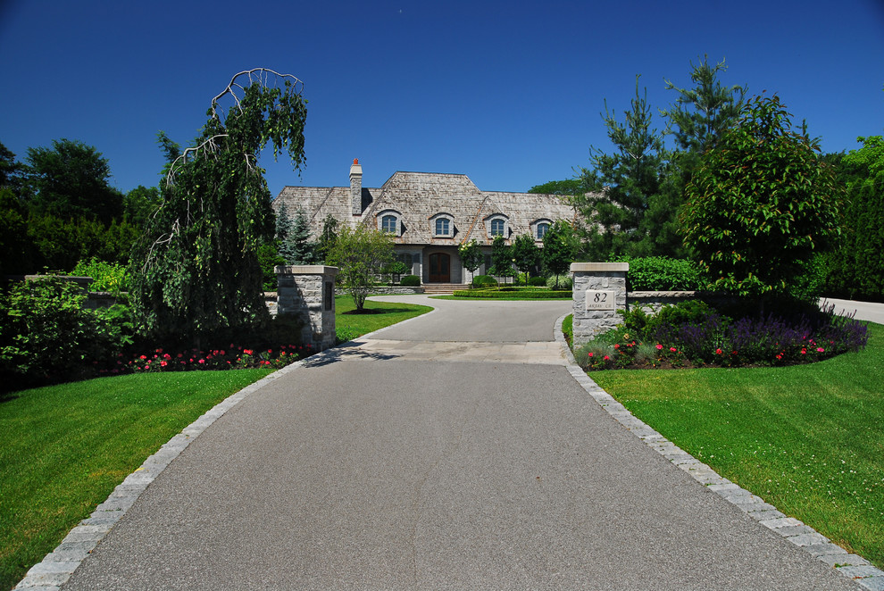 Large front yard full sun driveway in Toronto with natural stone pavers for summer.