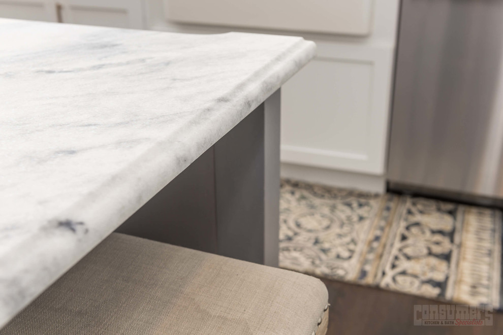 Eat-in kitchen - large u-shaped plywood floor eat-in kitchen idea in New York with a farmhouse sink, recessed-panel cabinets, white cabinets, quartzite countertops, white backsplash, ceramic backsplash, stainless steel appliances and an island