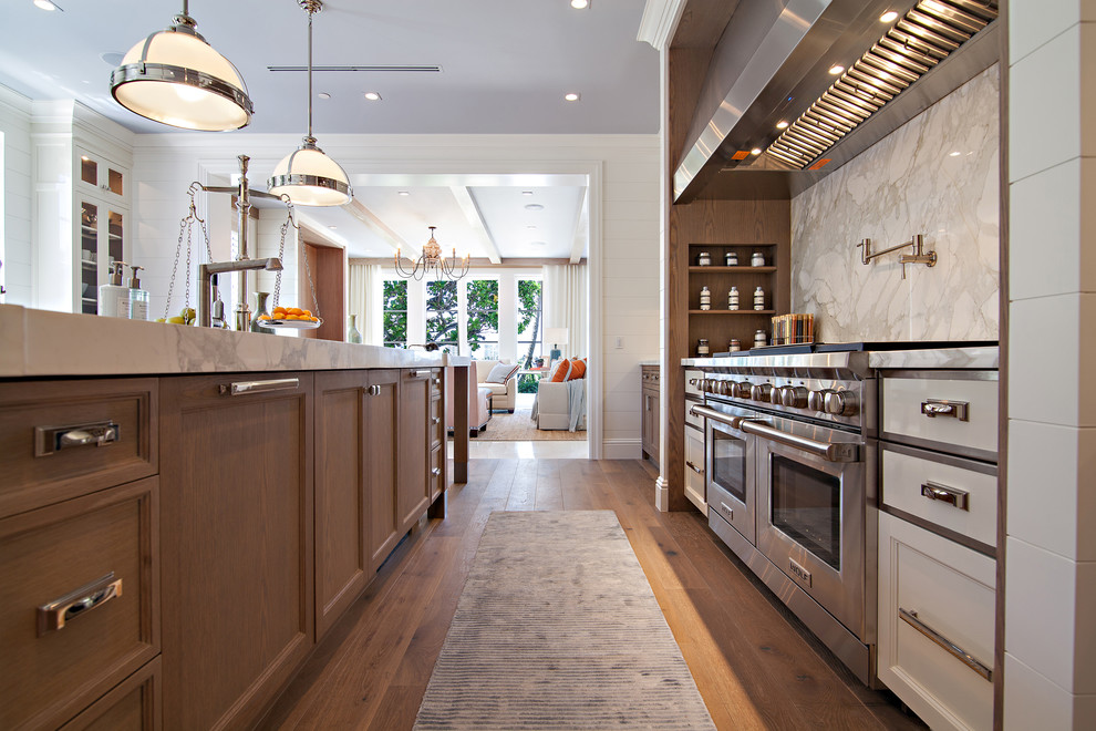 Example of a huge transitional medium tone wood floor kitchen design in Miami with an undermount sink, shaker cabinets, white cabinets, marble countertops, white backsplash, stone slab backsplash, white appliances and an island