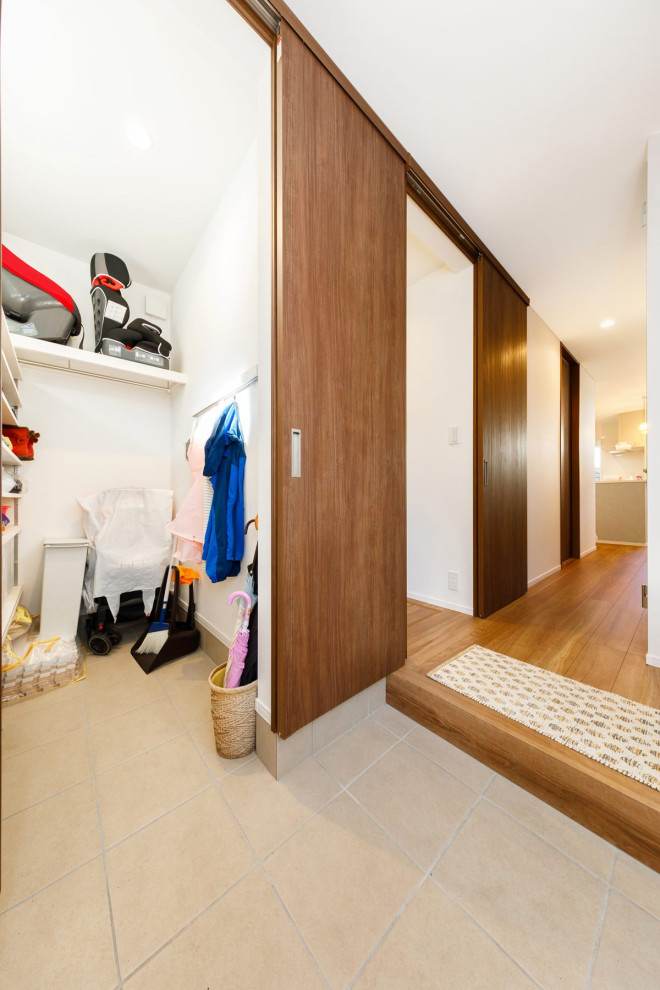 This is an example of a medium sized urban hallway in Other with white walls, a single front door, a dark wood front door, beige floors, a wallpapered ceiling and wallpapered walls.