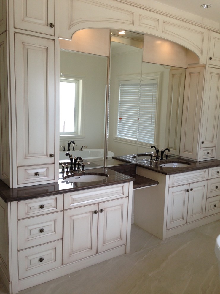 Photo of a large traditional master bathroom in Vancouver with raised-panel cabinets, white cabinets, white walls and an undermount sink.
