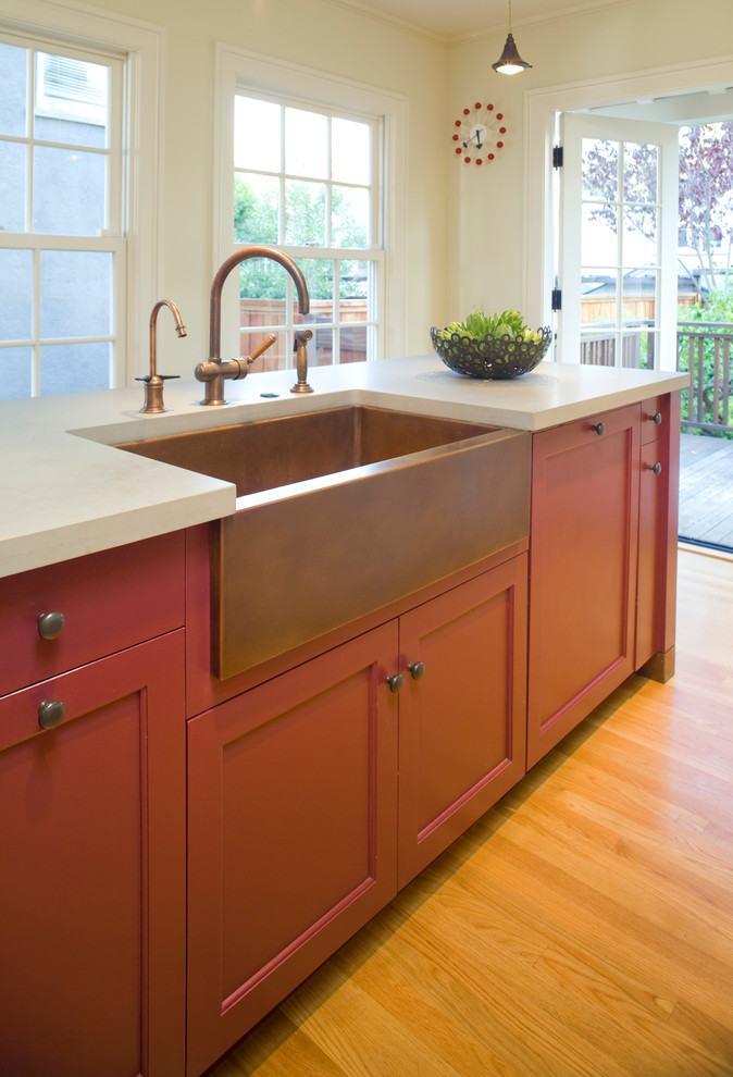 Photo of a mid-sized traditional kitchen in San Francisco with red cabinets, light hardwood floors, a farmhouse sink, recessed-panel cabinets and quartz benchtops.